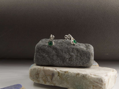 Orecchini a goccia con pietre colorate in argento su una base di pietra grigia