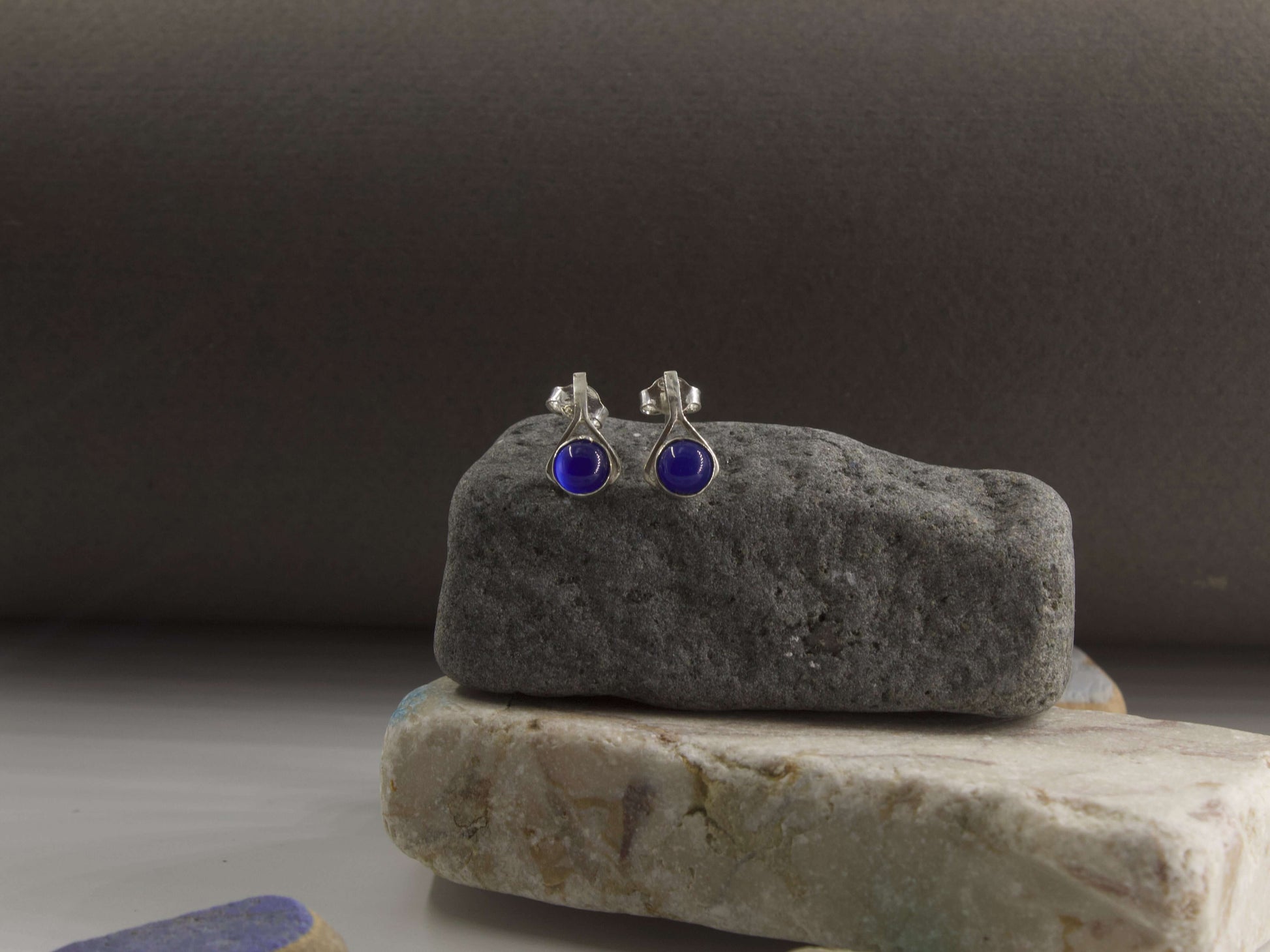 Orecchini a goccia pietra blu Glimoire con design elegante e montatura in argento su sfondo naturale