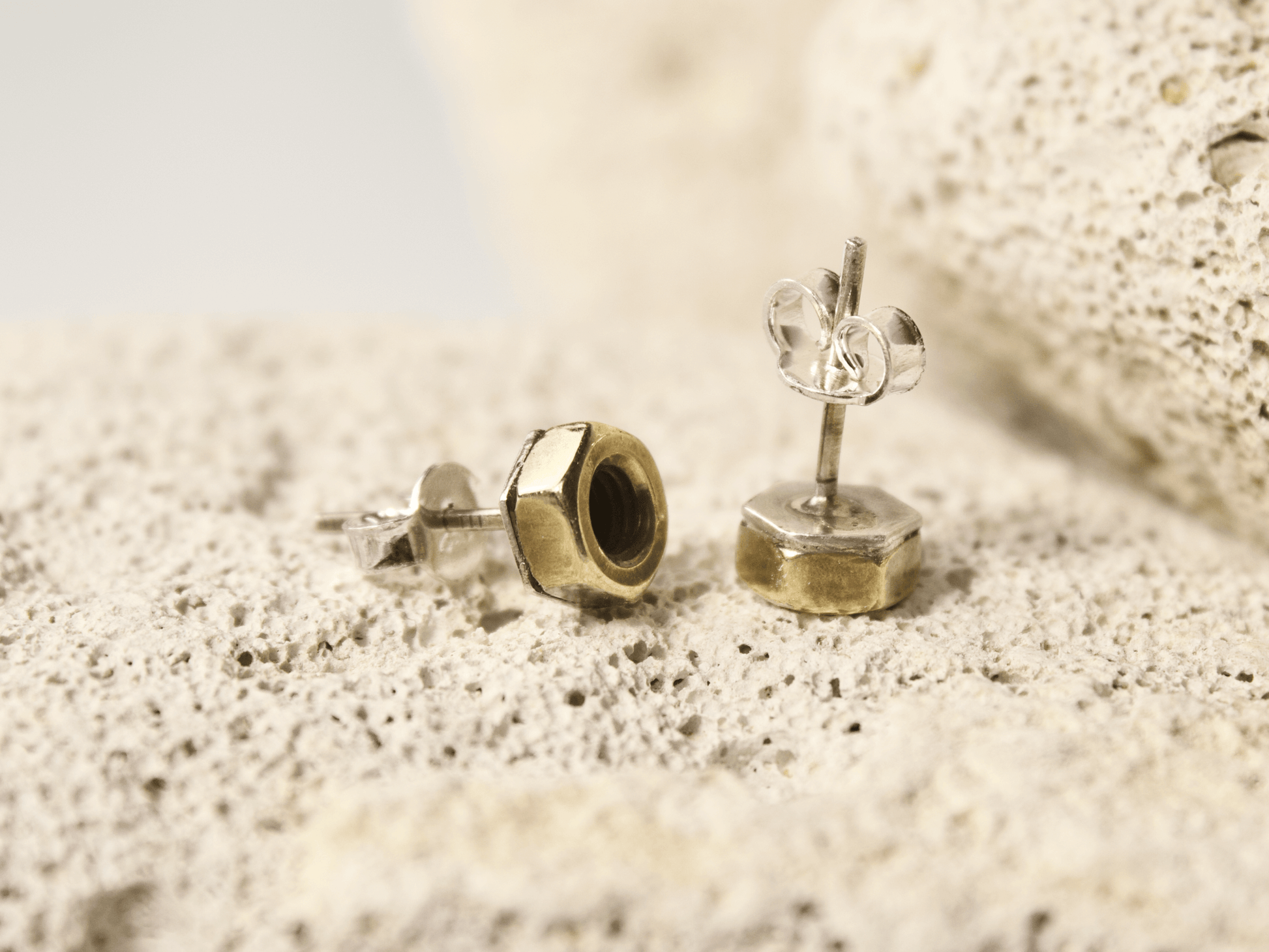 Orecchini a perno con bulloni in metallo lucido e finitura elegante, perfetti per uno stile unico