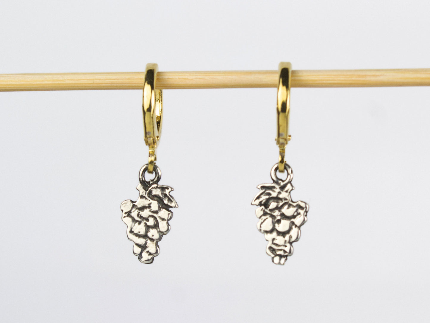 Orecchini a lobo in argento a forma di grappolo d'uva, con cerchietti in ottone dorato. Ogni frutto possiede una propria armonia di linee e forme. Nella sua semplicità si cela un'eleganza discreta.