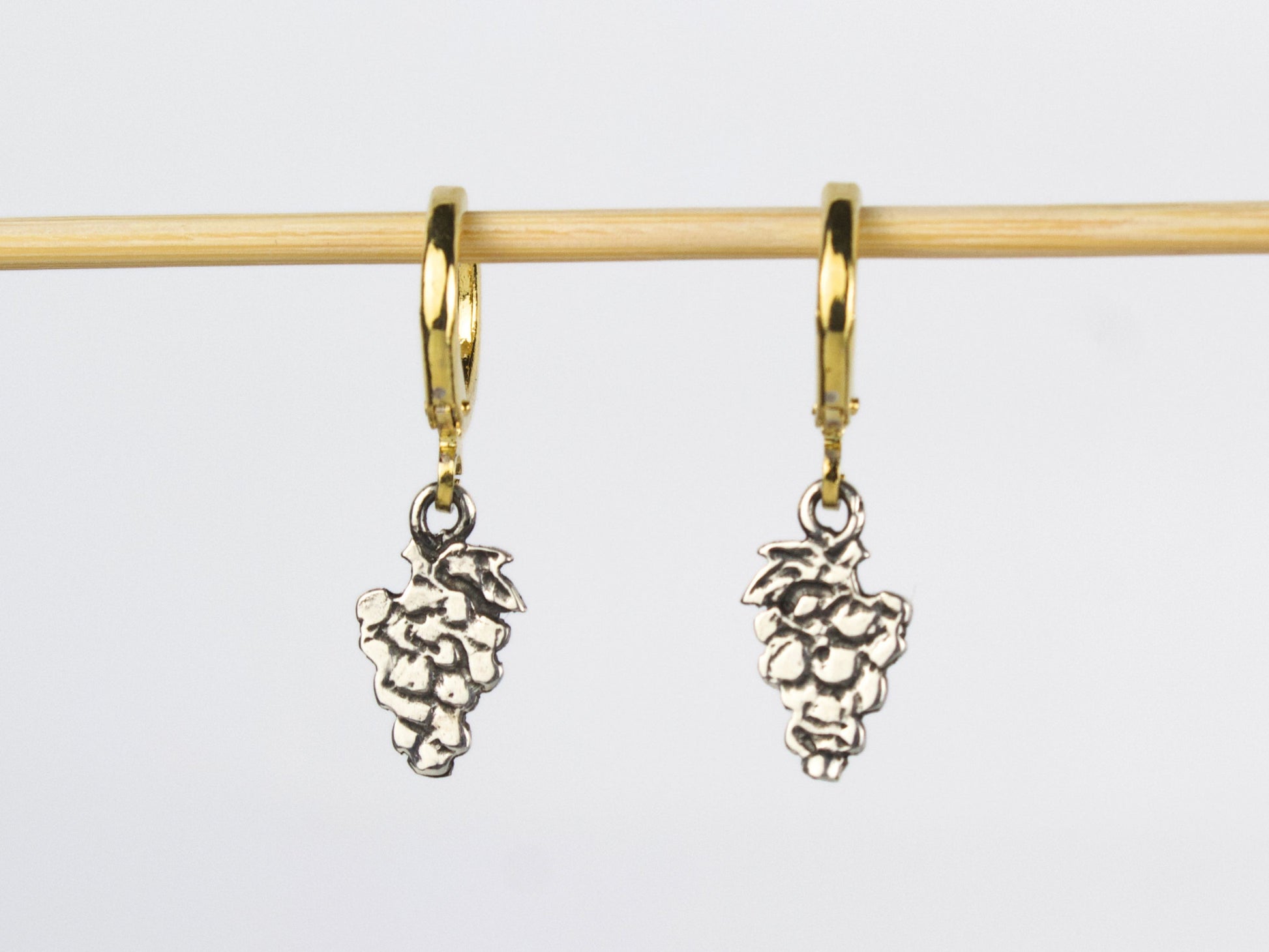 Orecchini a lobo in argento a forma di grappolo d'uva, con cerchietti in ottone dorato. Ogni frutto possiede una propria armonia di linee e forme. Nella sua semplicità si cela un'eleganza discreta.