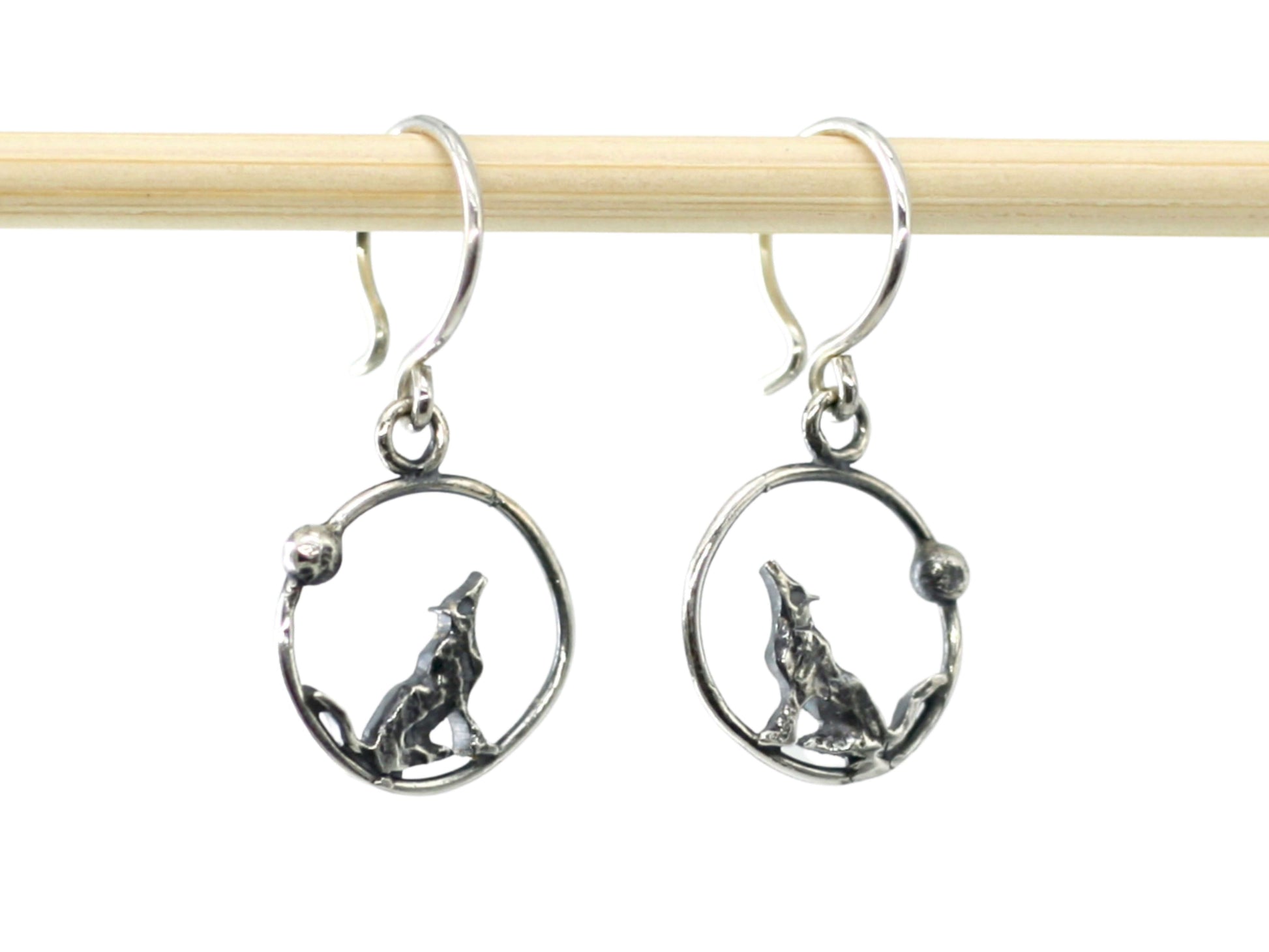 Orecchini lupi incisi a mano in argento con design di lupo che ulula dentro cerchio di Glimoire