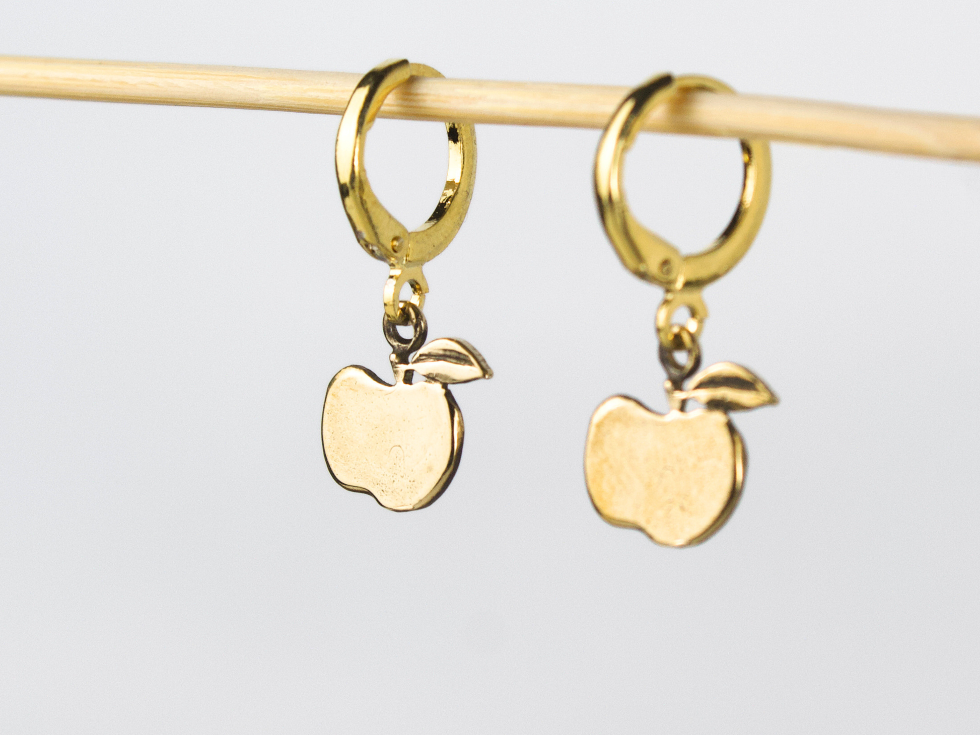 Dettaglio degli orecchini Mela in bronzo con cerchietti in ottone dorato.