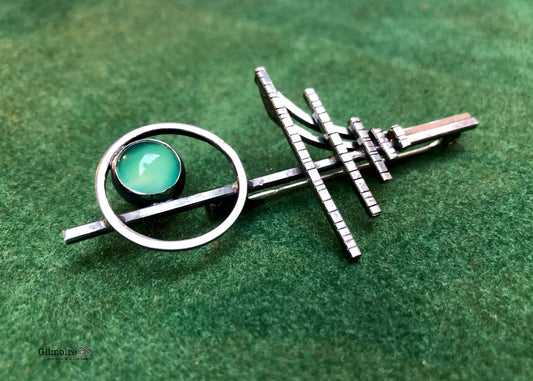 Spilla geometrica in argento con pietra verde e design geometrico in argento