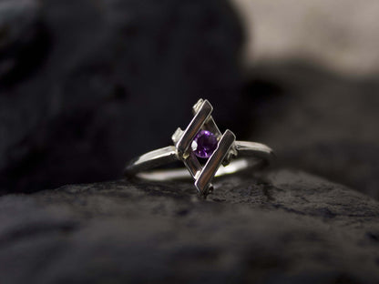 Anello Glimoire in argento con pietra viola centrale su sfondo scuro
