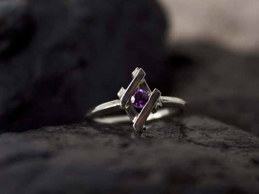 Anello Glimoire in argento con pietra viola centrale su sfondo scuro
