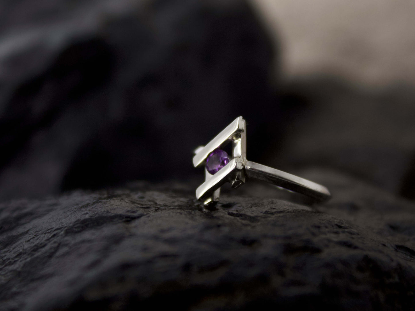 Anello Glimoire in argento con pietra viola incastonata su sfondo scuro