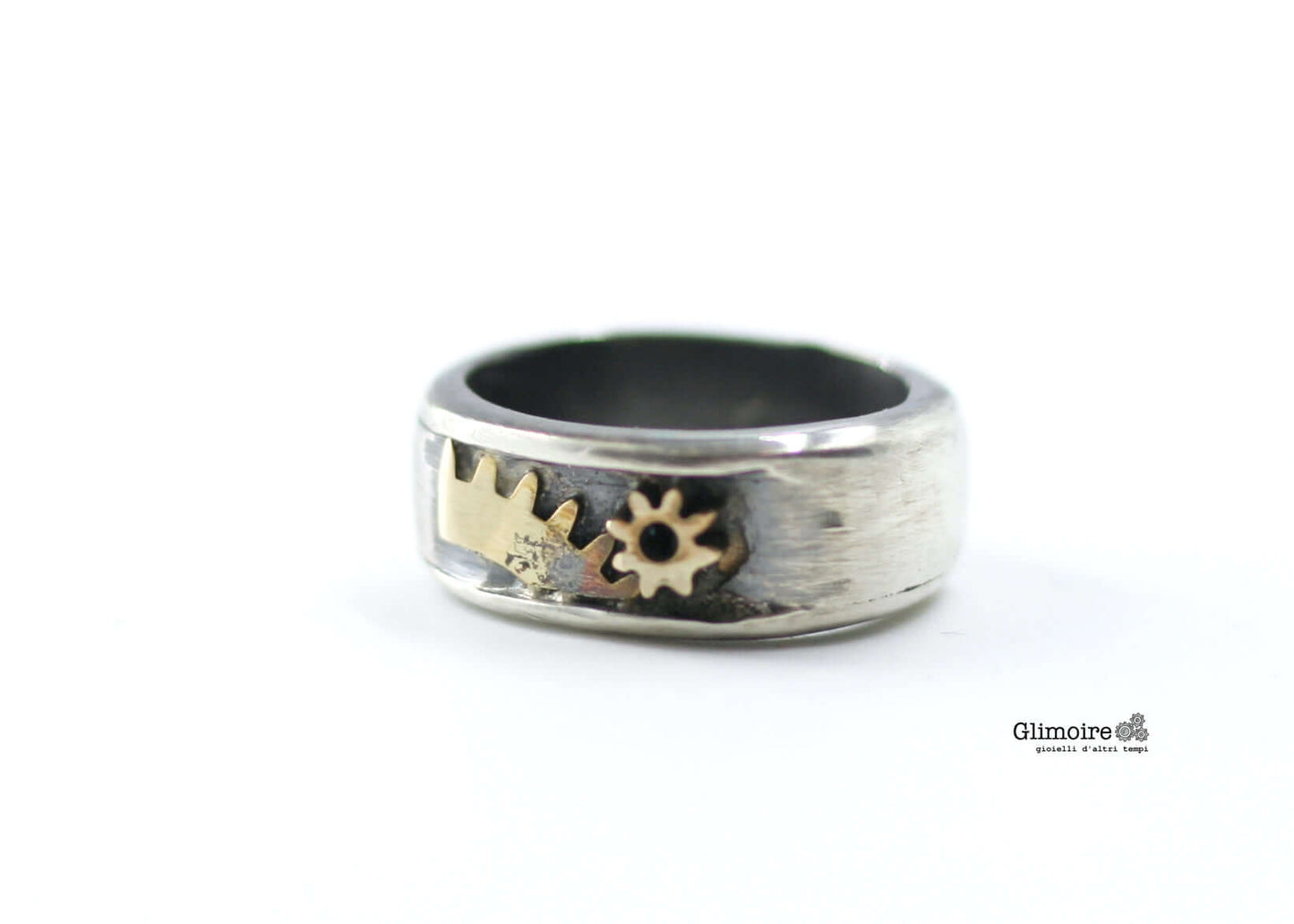 Anello a fascia in argento brunito con ingranaggi di sveglia in ottone incastonati
