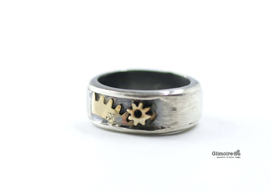 Anello a fascia in argento brunito con ingranaggi di sveglia in ottone incastonati