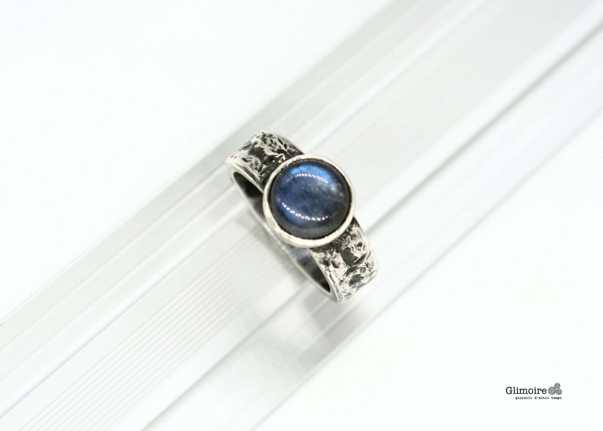 Anello in argento con pietra blu di Glimoire dal design elegante con finitura martellata