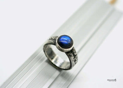 Anello in argento con labradorite, con finitura dettagliata e forma rotonda, su sfondo neutro