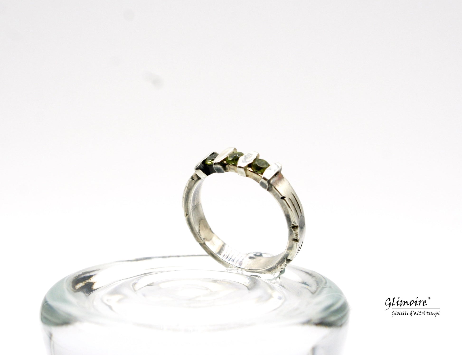 Anello in argento con pietre verdi di Glimoire su sfondo bianco, elegante design artigianale