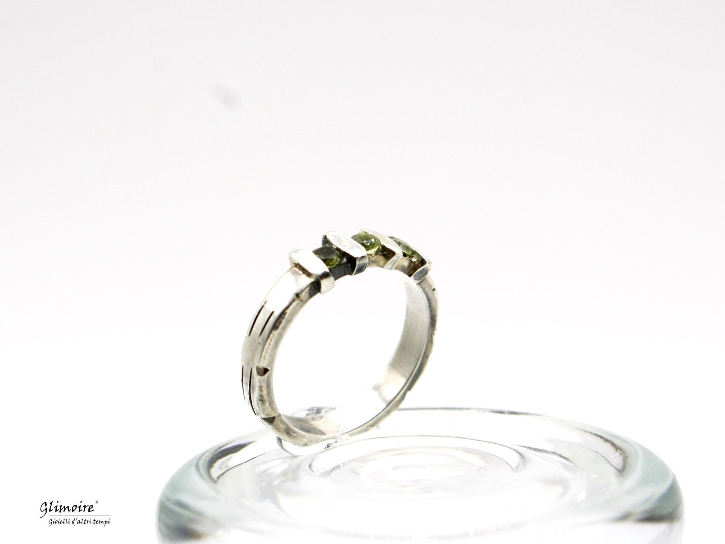 Anello in argento con pietre verdi su base di vetro con design moderno elegante