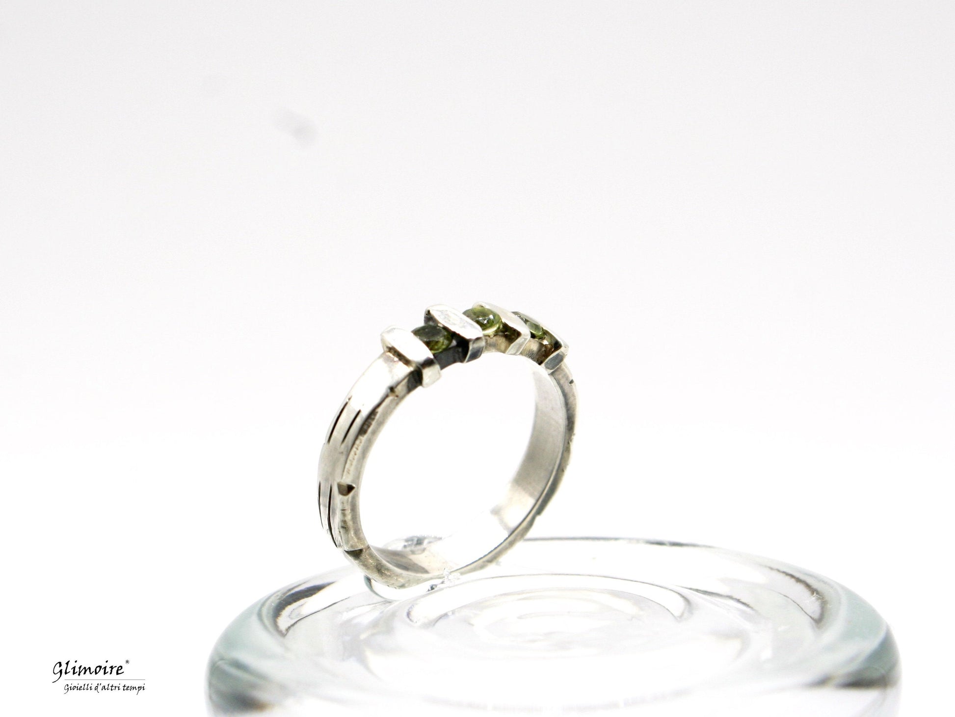 Anello in argento con pietre verdi su base di vetro con design moderno elegante