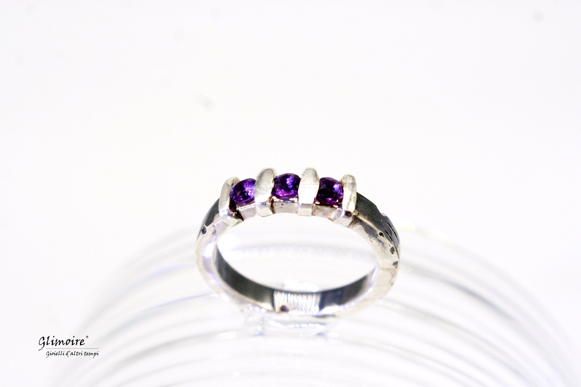 Anello in argento con pietre verdi e dettagli ametista di Glimoire su sfondo bianco