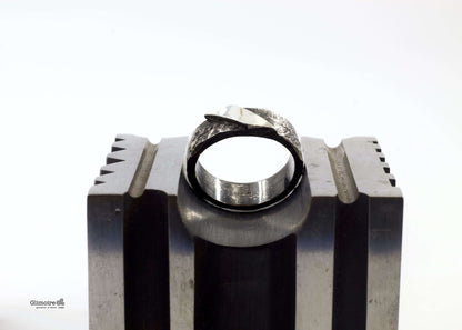 Anello a fascia in argento battuto Glimoire su supporto metallico con finitura martellata e texture artigianale