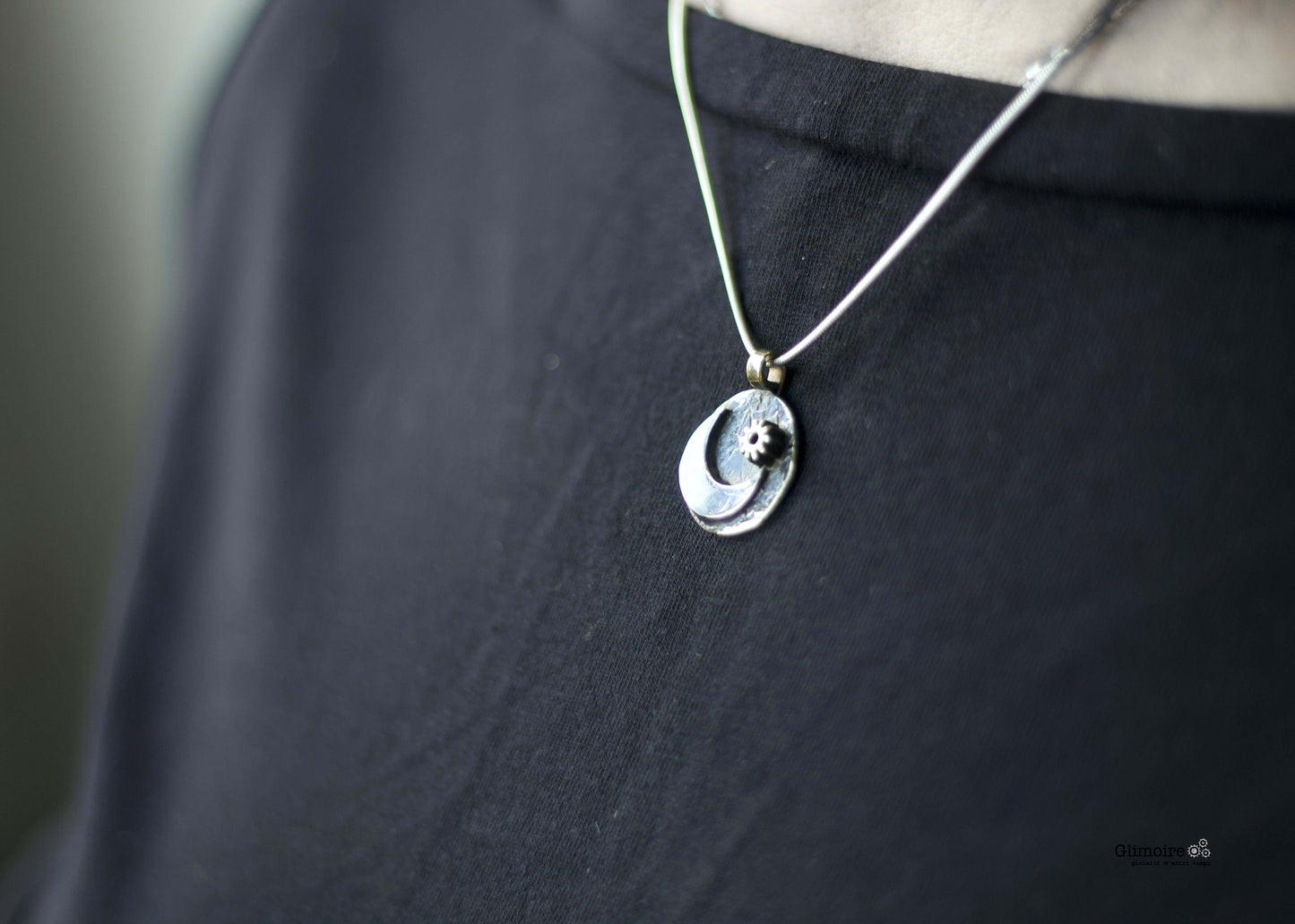 Glimoire collana luna con pendente a mezzaluna e piccolo sole su catena sottile indossata su maglia nera