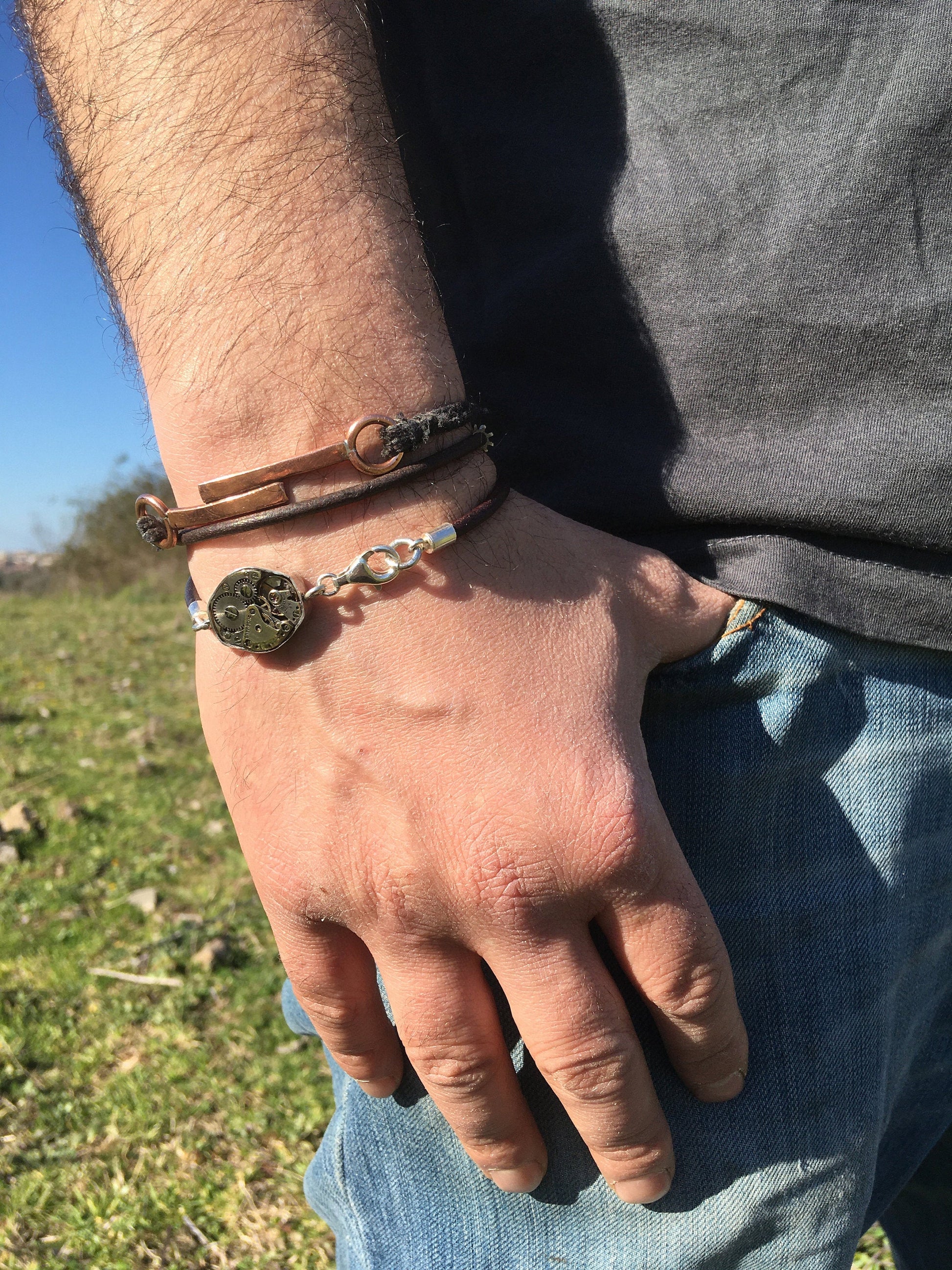 Bracciale in argento con meccanismo di orologio indossato su un polso,