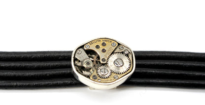 Bracciale in cuoio nero con meccanismo e dettagli metallici di design firmato Glimoire