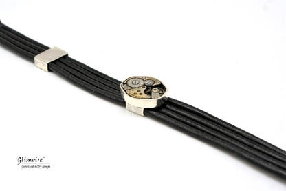 Bracciale in cuoio nero con meccanismo Glimoire a più fili e dettaglio orologio vintage