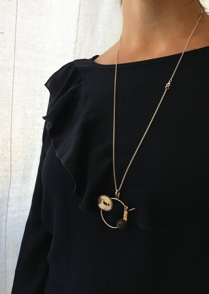 Collana cerchio pietra lavica fatta a mano indossata su una maglietta nera con rouches