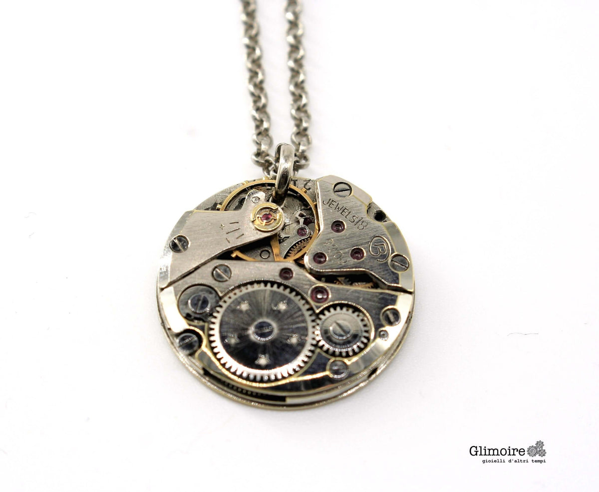 Dettaglio del ciondolo con meccanismo d orologio vintage e rubini a vista