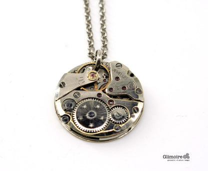 Dettaglio del ciondolo con meccanismo d orologio vintage e rubini a vista