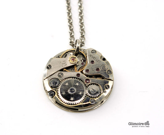 Dettaglio del ciondolo con meccanismo d orologio vintage e rubini a vista