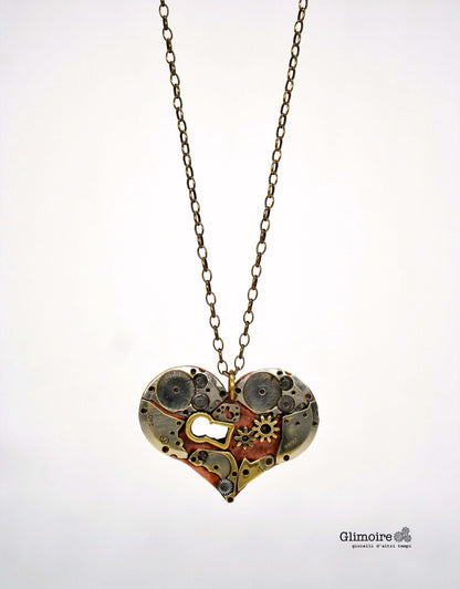 Collana con pendente a forma di cuore meccanico, realizzato con ingranaggi di orologeria vintage e una piccola serratura.