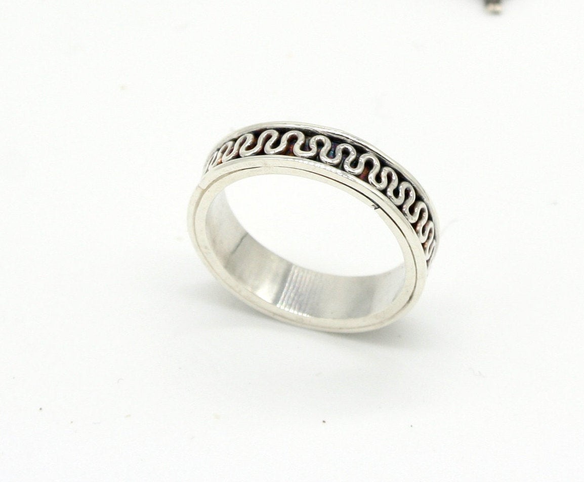 Anello Glimoire fede etrusca in argento con design a onde intrecciate su sfondo nero