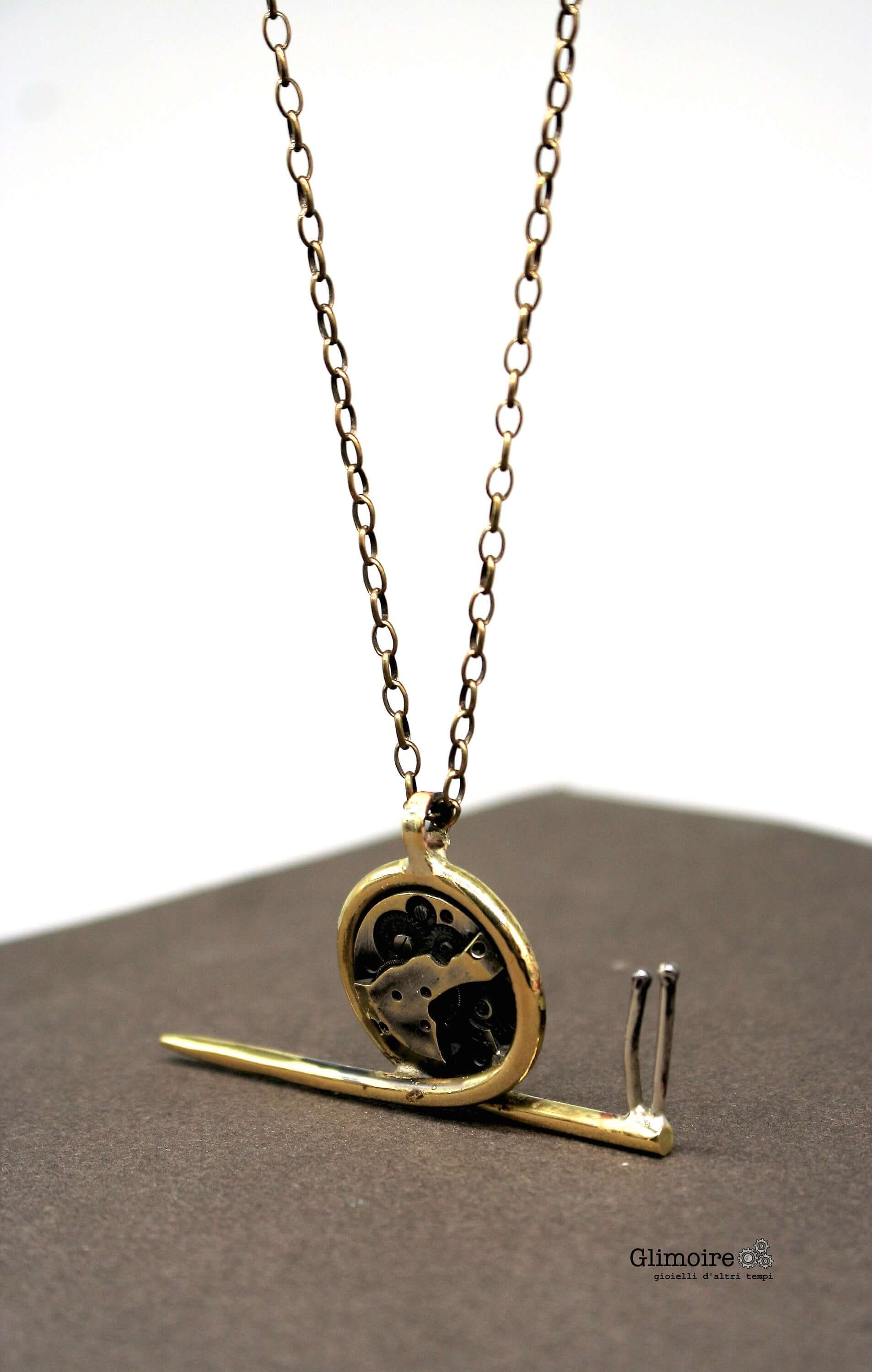 Collana chiocciola steampunk Glimoire con pendente a forma di chiocciola in metallo dorato e ingranaggi neri