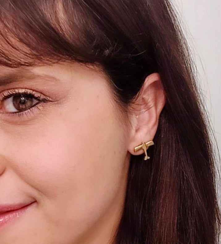 Orecchini aerei Glimoire in metallo dorato indossati da donna con capelli castani