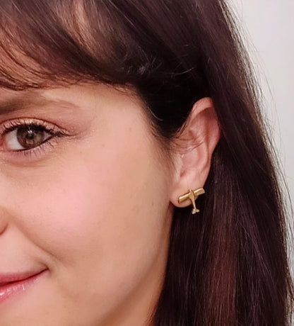 Orecchini aerei Glimoire in metallo dorato indossati da donna con capelli castani