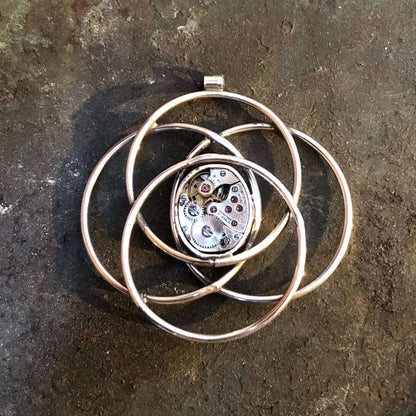 Pendente in argento ad orbite atomiche con meccanismo d orologio al centro
